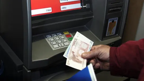 Un hombre retira euros de un cajero automático Un hombre retira euros de un cajero automático