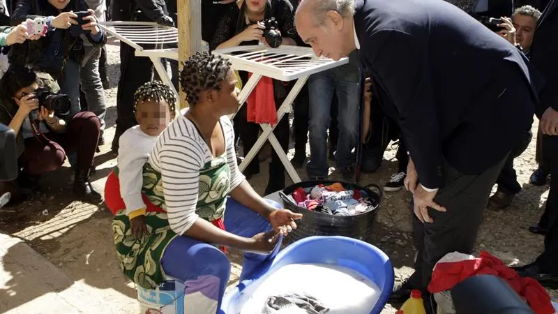 El ministro del Interior, Jorge Fernández Díaz, conversa con una inmigrante