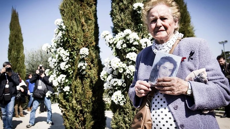 Una mujer sostiene una foto de una de las víctimas