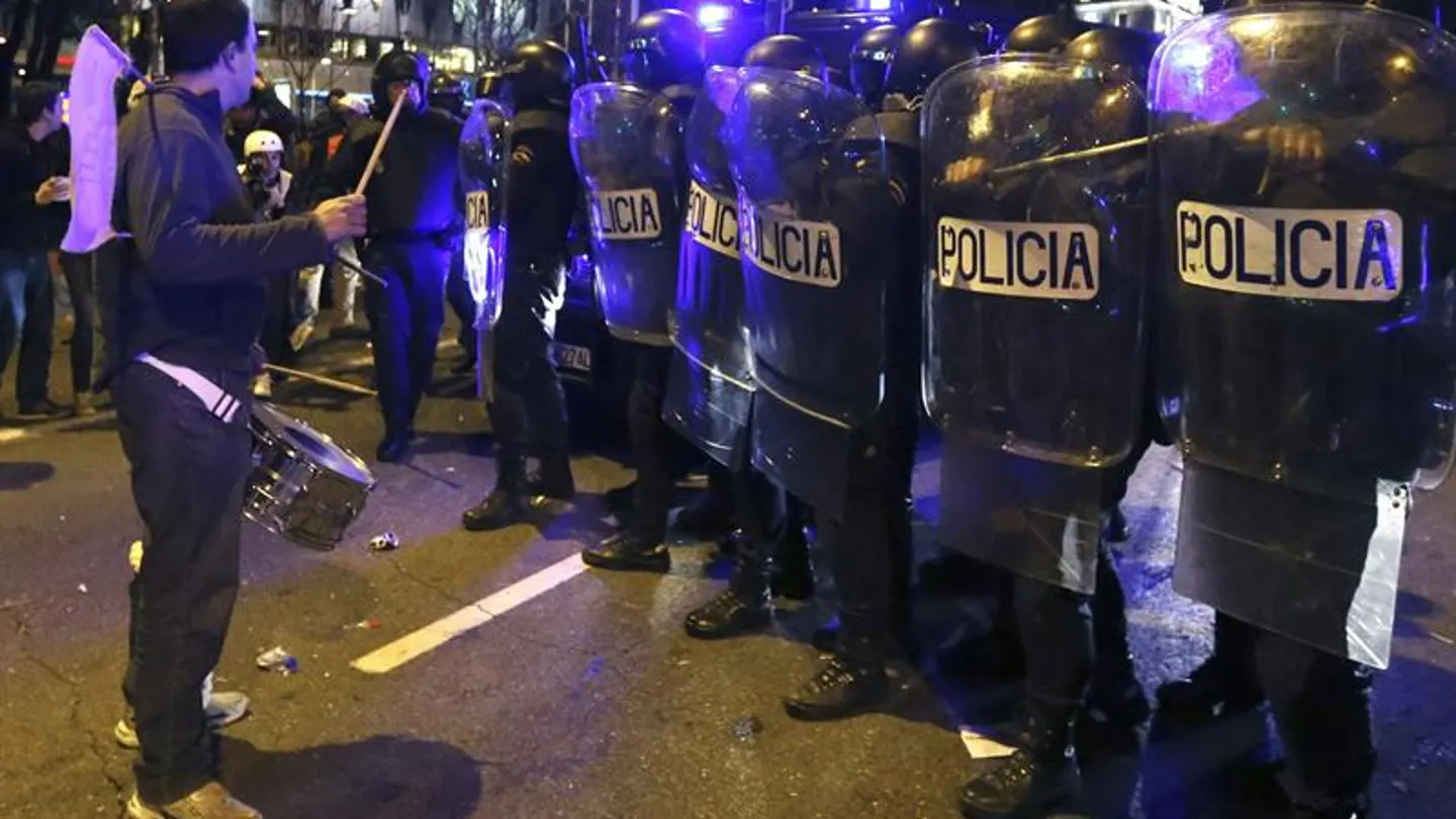 Un manifestante toca el tambor delante de los policías antidisturbios en la Plaza de Colón Un manifestante toca el tambor delante de los policías antidisturbios en la Plaza de Colón