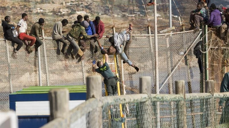 Un agente de la Guardia Civil ayuda a uno de los 25 inmigrantes