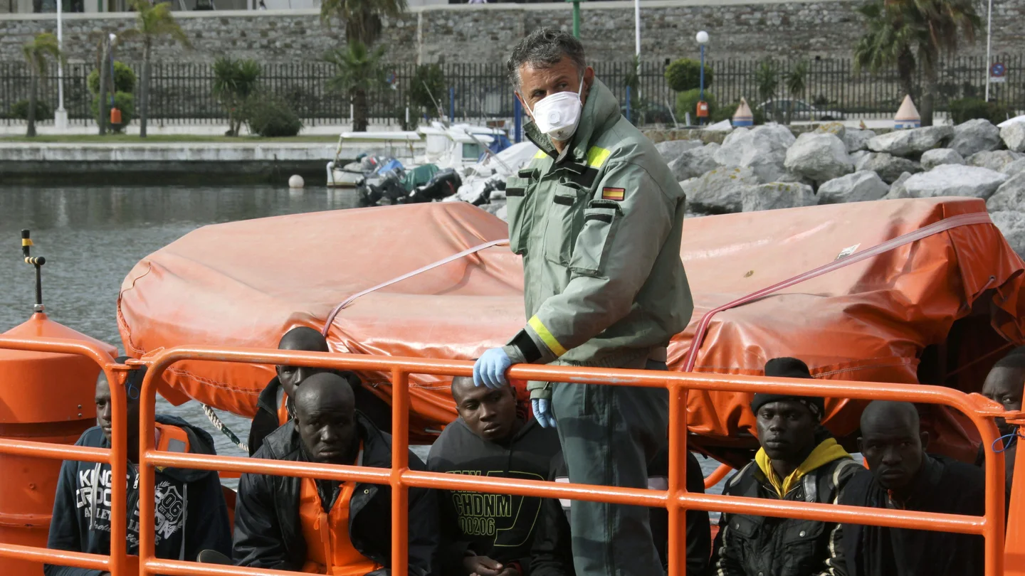 Un agente de la Guardia Civil con varios migrantes en una foto de archivo Un agente de la Guardia Civil con varios migrantes en una foto de archivo
