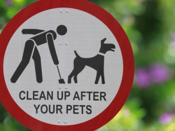 Cartel pidiendo que los dueños recojan las deposiciones de sus perros