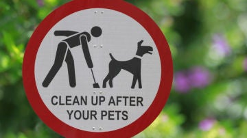 Cartel pidiendo que los dueños recojan las deposiciones de sus perros