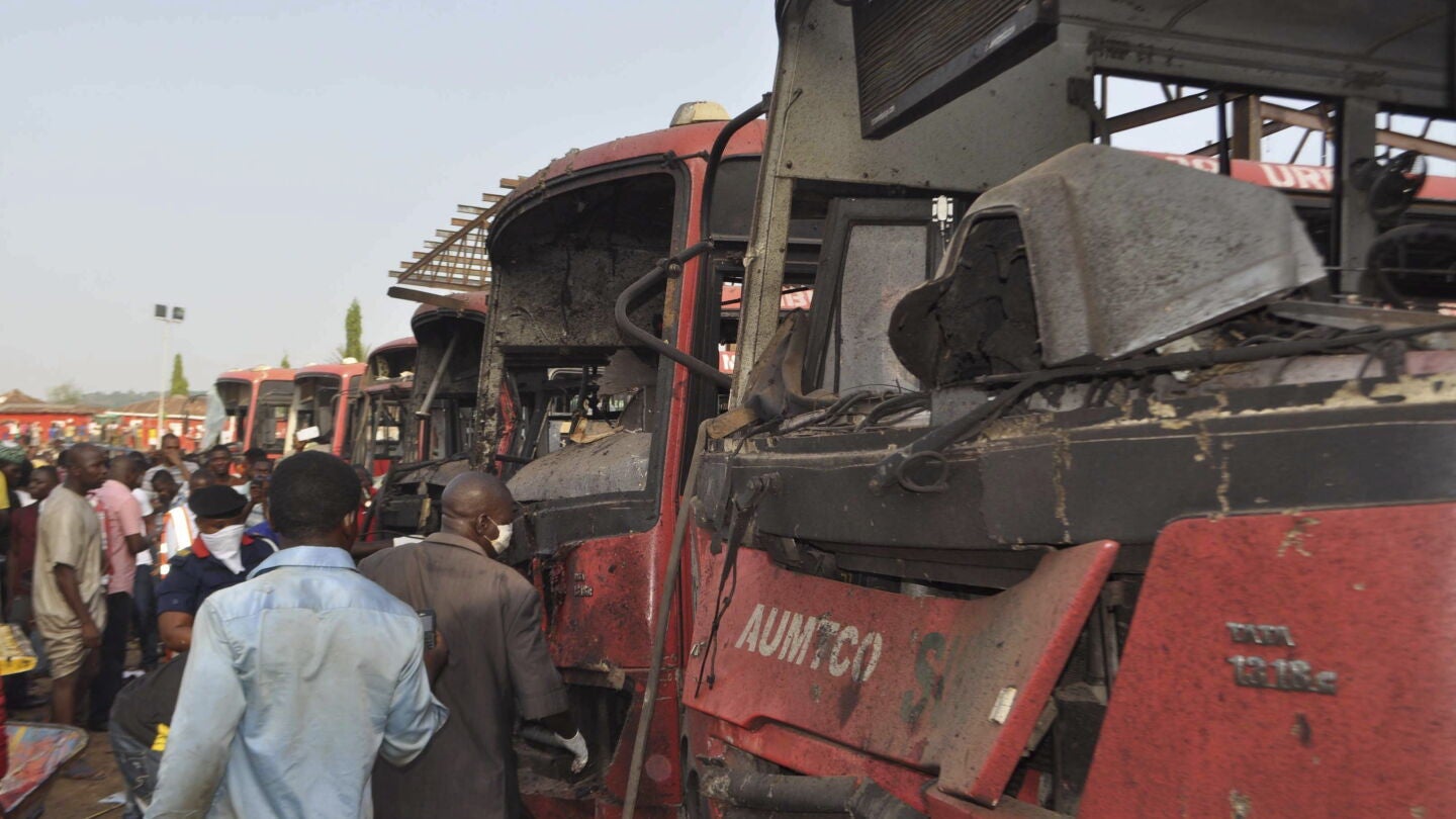 Algunos ciudadanos observan da&ntilde;os en varios veh&iacute;culos tras una explosi&oacute;n en la estaci&oacute;n de autobuses Nyana a las afueras de Abuya (Nigeria)