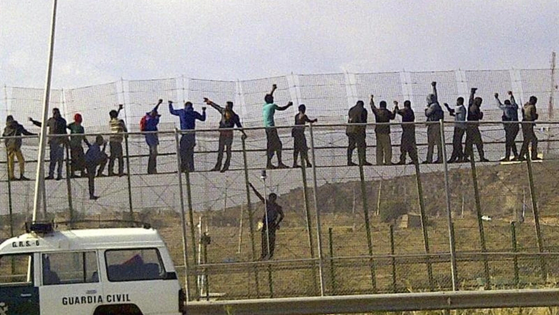 Decenas de inmigrantes, encaramados en la valla de Melilla
