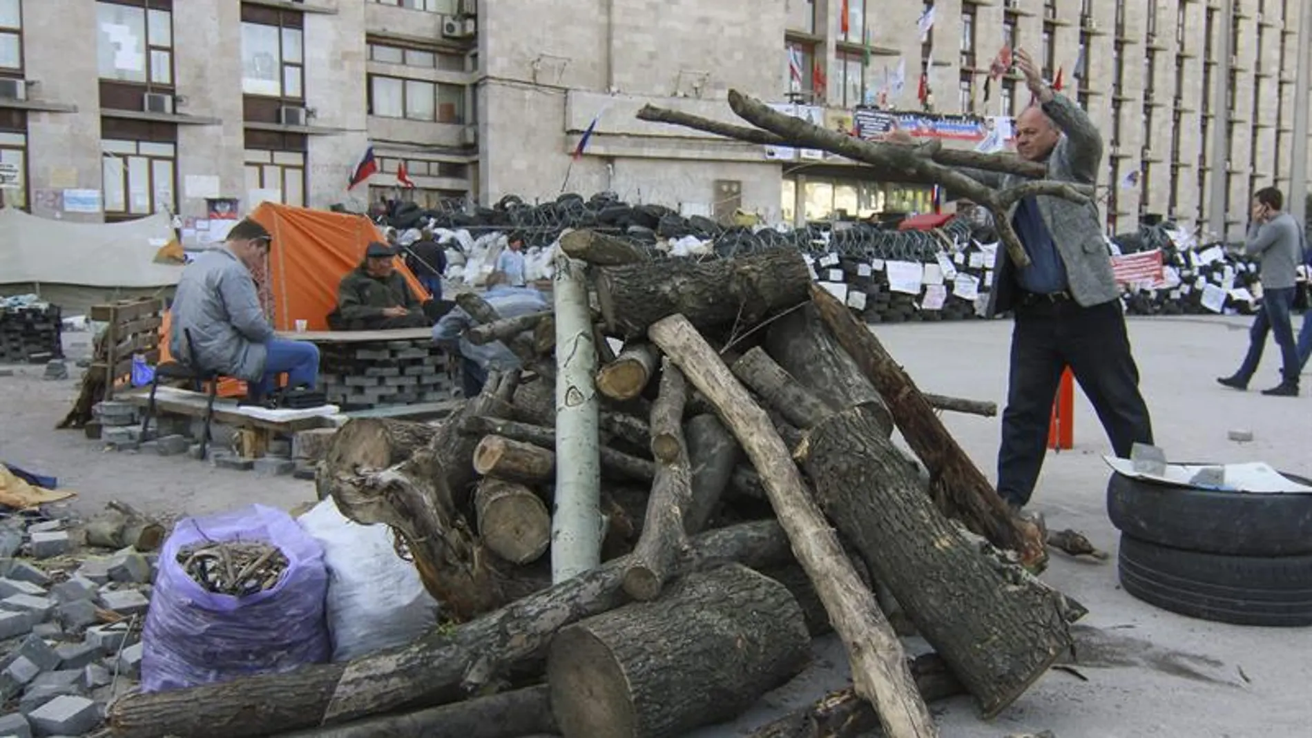Un manifestante prorruso amontonta madera junto a una barricada