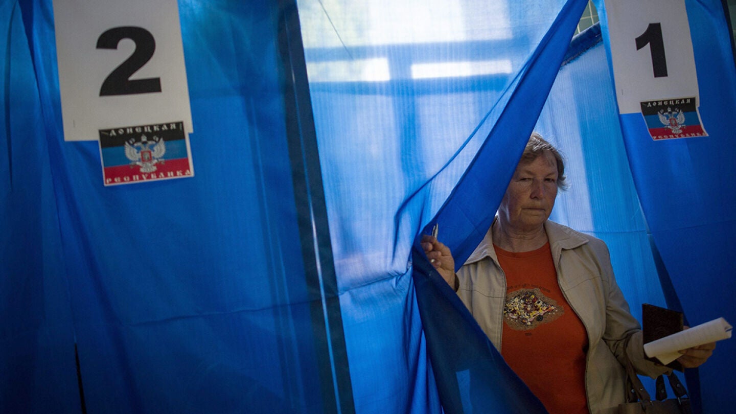 Una mujer sale de la cabina de votaci&oacute;n, durante el refer&eacute;ndum, en un colegio electoral en Donetsk, Ucrania