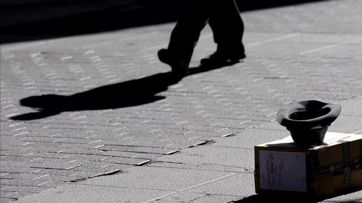 Una persona pidiendo dinero en la calle Una persona pidiendo dinero en la calle
