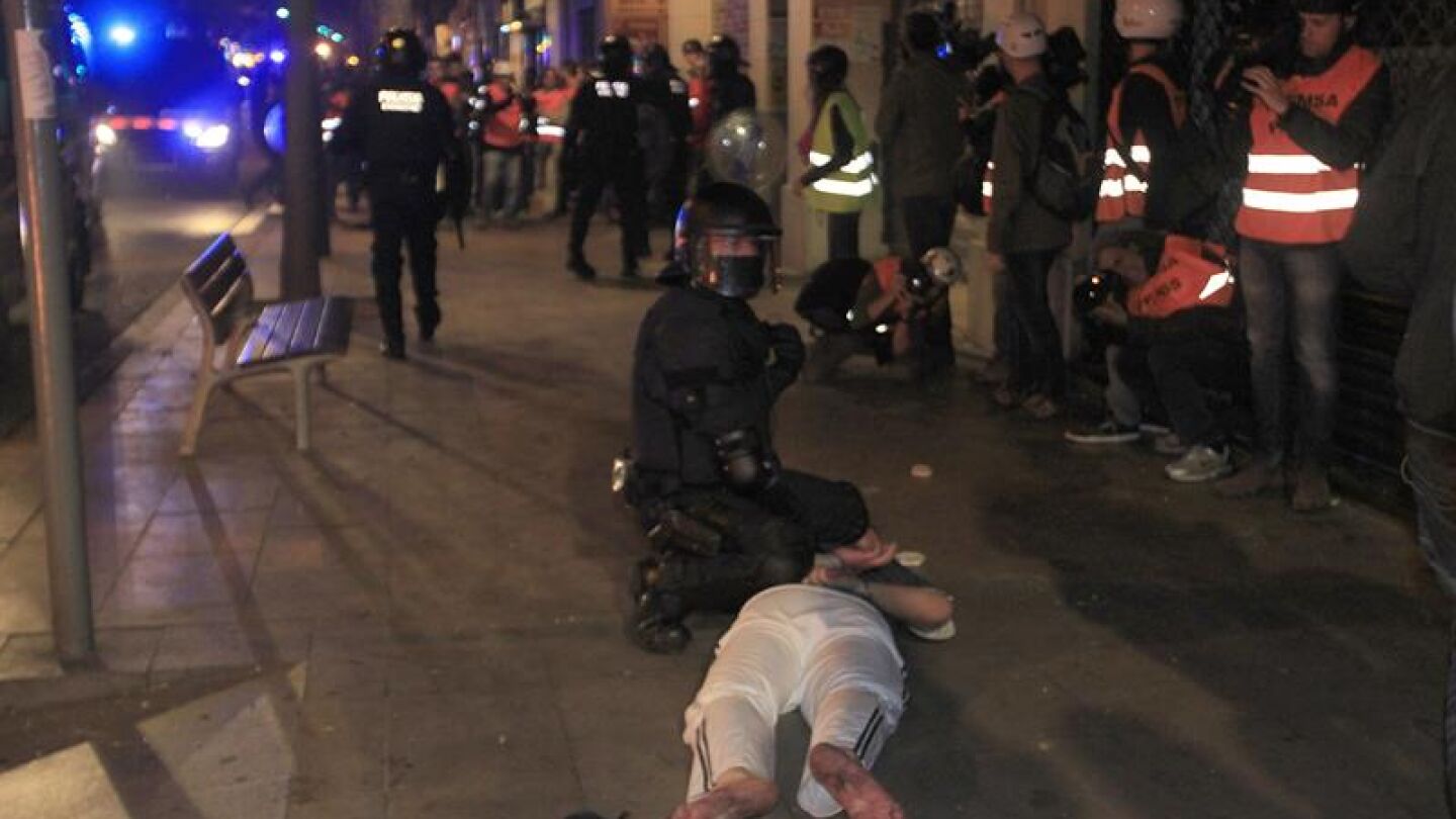 Un Mosso deteniendo a un manifestante
