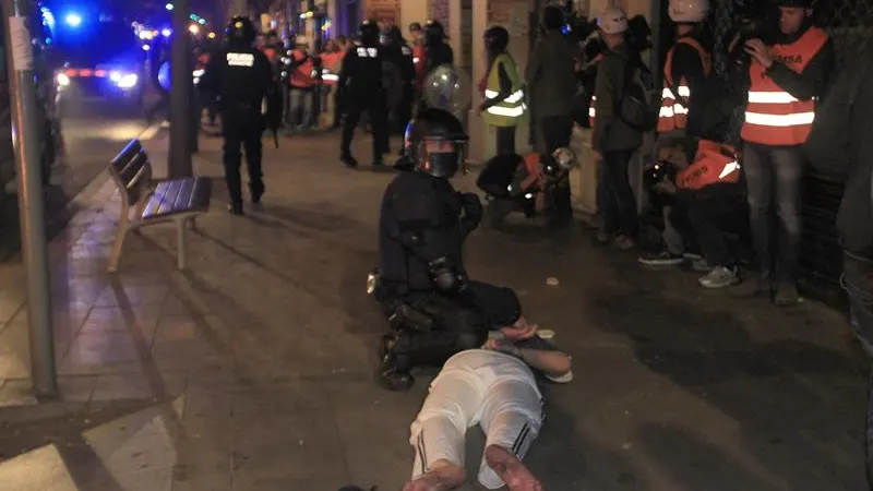 Un Mosso deteniendo a un manifestante