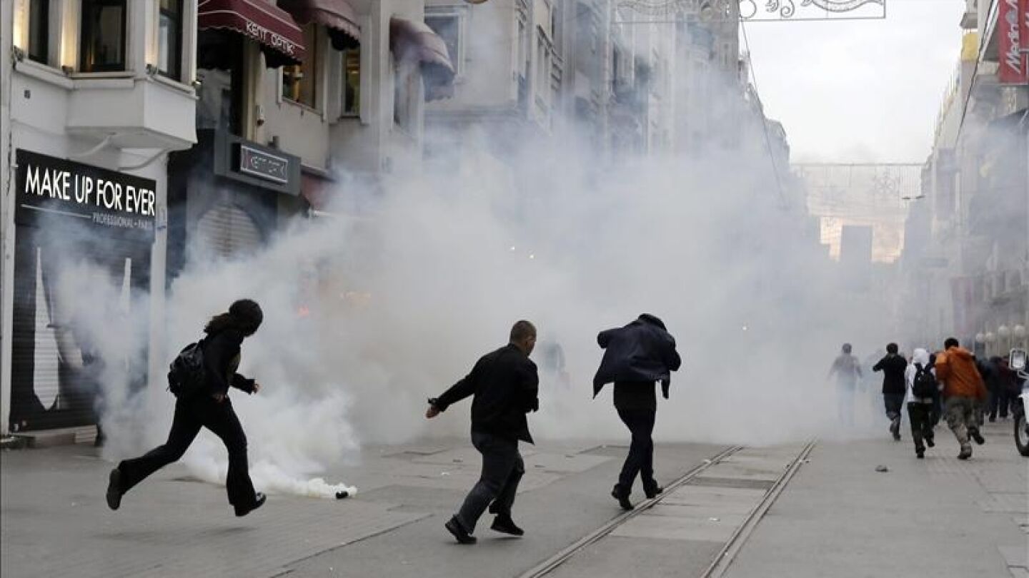 La gente escapa de una nube de gases lanzados por los antidisturbios turcos