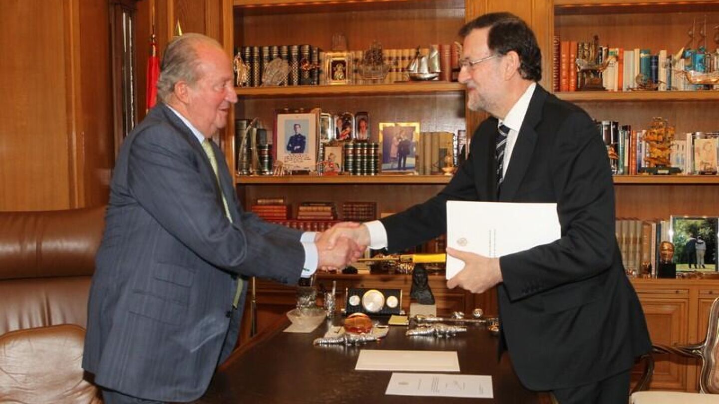 El Rey Juan Carlos I estrecha la mano de Rajoy tras su abdicaci&oacute;n
