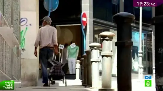 Un hombre camina con un carro de la compra Un hombre camina con un carro de la compra