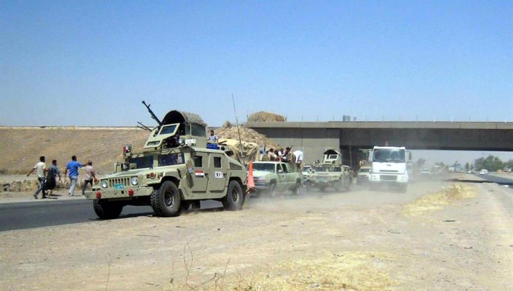 Vehículos militares y varias personas en Irak