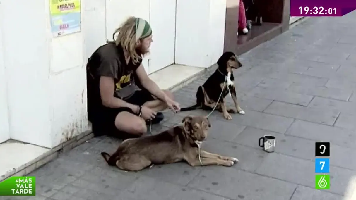 Un mendigo con dos perros