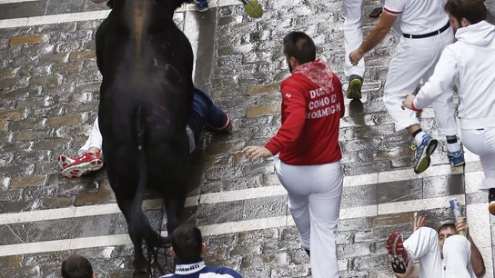 Un mozo cae al pasar uno de los toros por la calle Mercaderes Un mozo cae al pasar uno de los toros por la calle Mercaderes