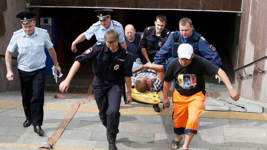 Servicios de Emergencias rusos llevan en camilla a un joven que result&oacute; herido