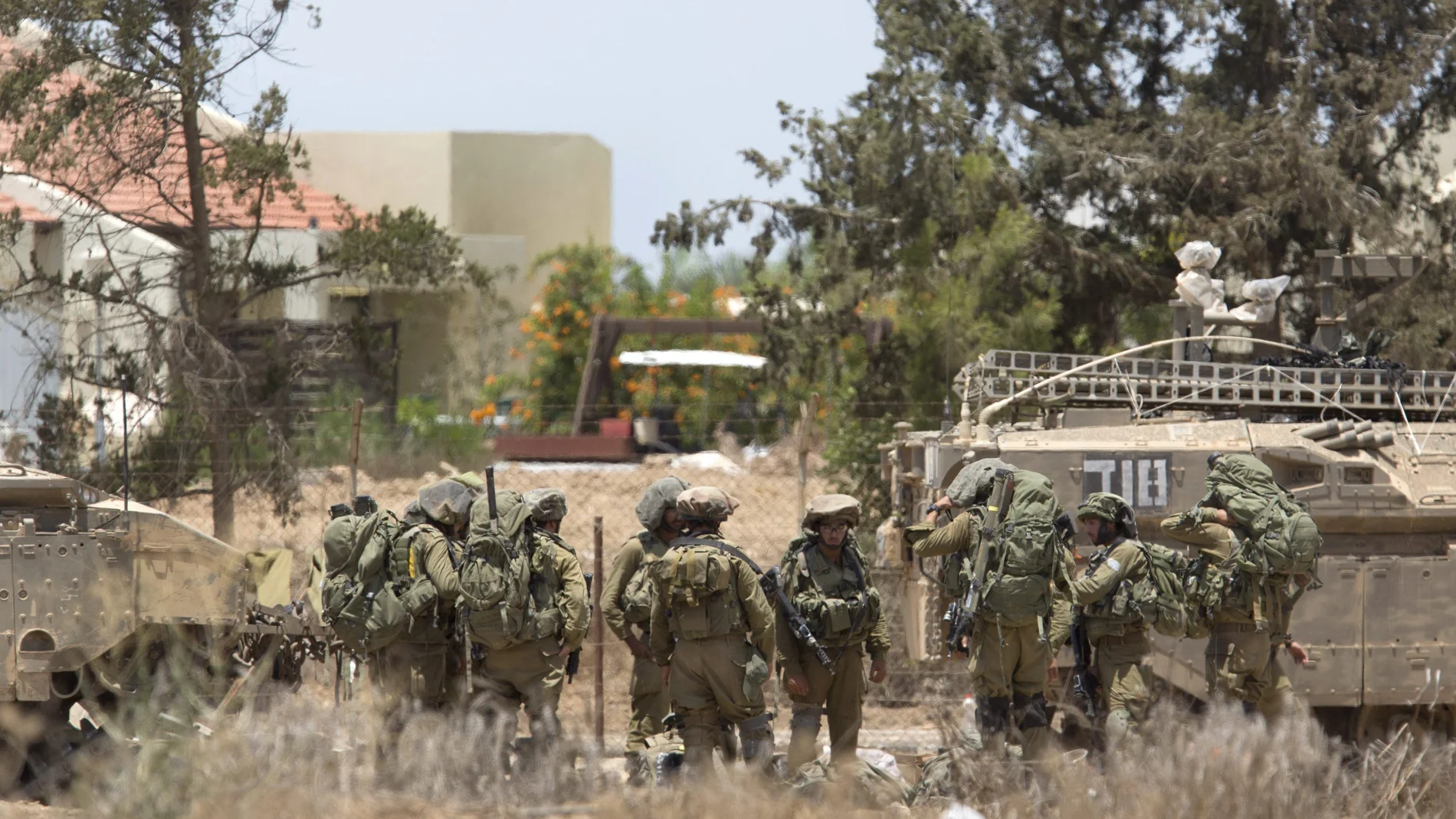 Miembros de la infantería del Ejército israelí permanecen cerca de un tanque de combate