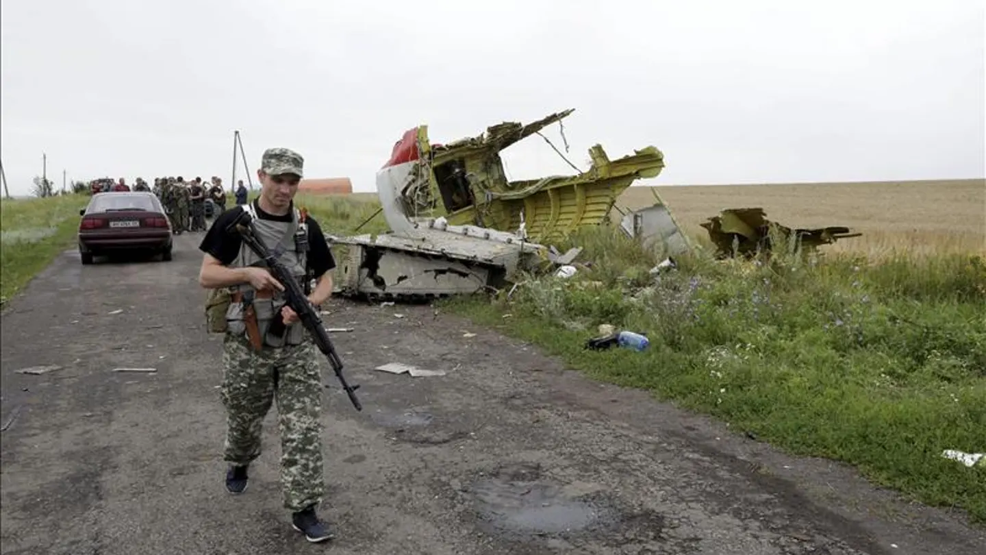 Un rebelde prorruso pasa al lado de restos de fuselaje del avión Boeing 777 del vuelo MH 17 Un rebelde prorruso pasa al lado de restos de fuselaje del avión Boeing 777 del vuelo MH 17