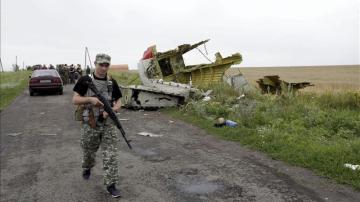 Un rebelde prorruso pasa al lado de restos de fuselaje del avión Boeing 777 del vuelo MH 17