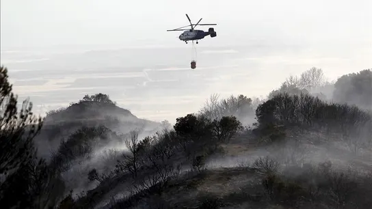 Un helicóptero en tareas de extinción del incendio que se declaró en la zona de la Cruz, el término municipal de Ujué (Navarra) Un helicóptero en tareas de extinción del incendio que se declaró en la zona de la Cruz, el término municipal de Ujué (Navarra)