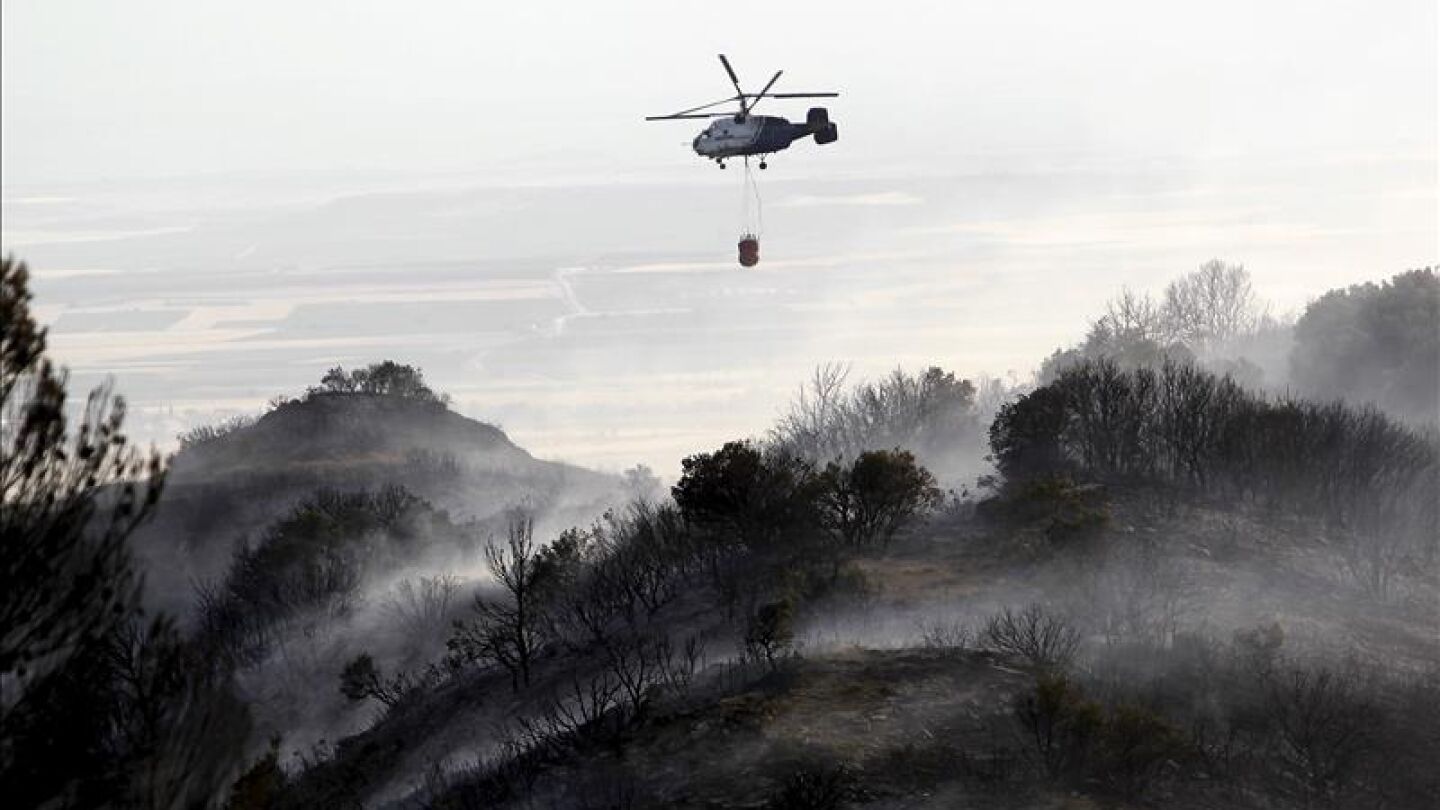 Un helic&oacute;ptero en tareas de extinci&oacute;n del incendio que se declar&oacute; en la zona de la Cruz, el t&eacute;rmino municipal de Uju&eacute; (Navarra)