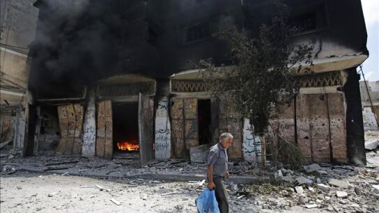 Un palestino huye de su casa en el barrio de Al Shejaeiya