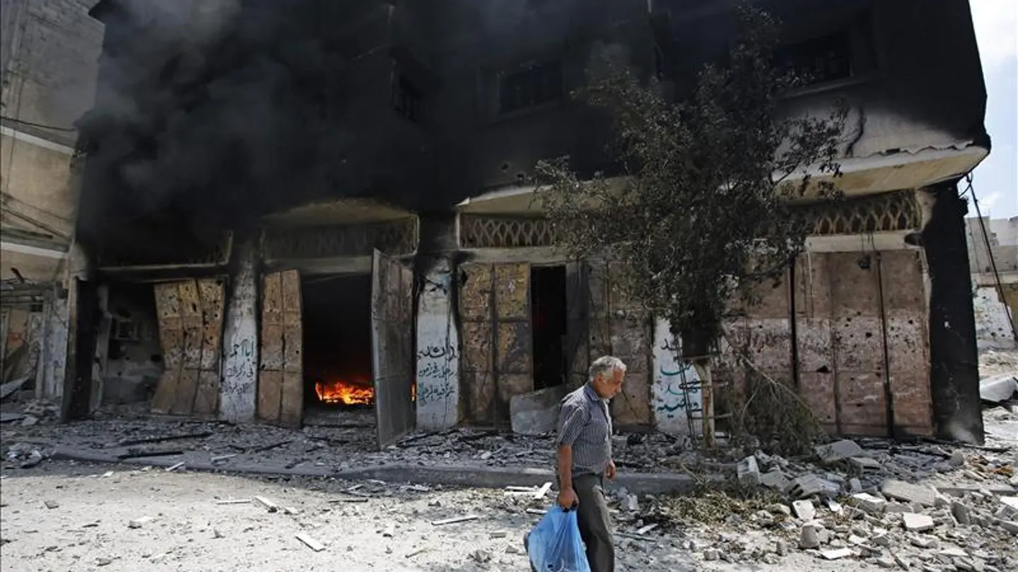 Un palestino huye de su casa en el barrio de Al Shejaeiya Un palestino huye de su casa en el barrio de Al Shejaeiya