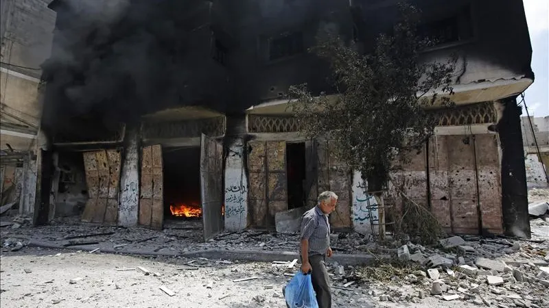 Un palestino huye de su casa en el barrio de Al Shejaeiya