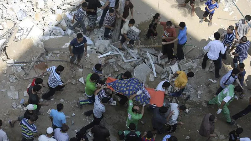 Palestinos con el cuerpo de una mujer encontrada entre escombros