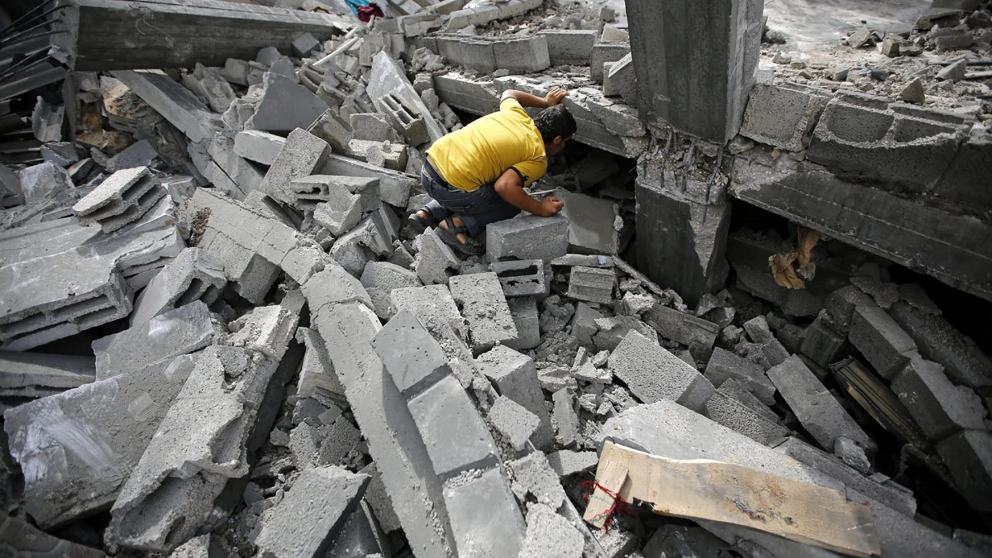 Un palestino busca entre los escombros tras un bombardeo israelí Un palestino busca entre los escombros tras un bombardeo israelí