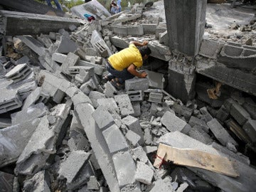 Un palestino busca entre los escombros tras un bombardeo israelí
