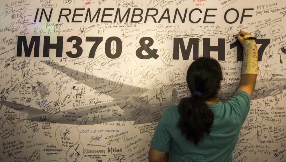 Una joven escribe un mensaje en memoria de las víctimas del avión derribado en Ucrania