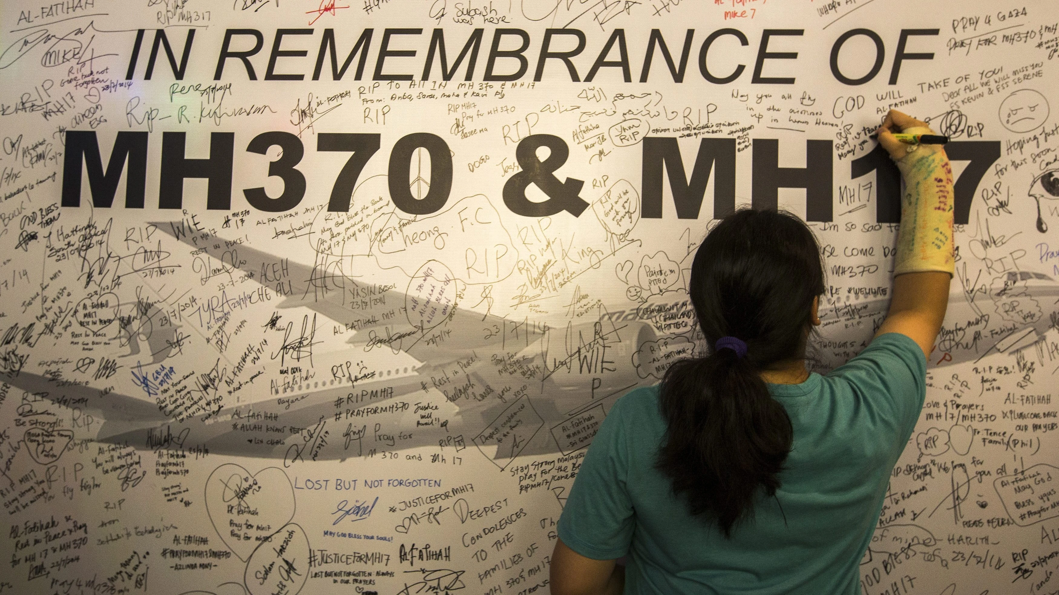 Una joven escribe un mensaje en memoria de las víctimas del avión derribado en Ucrania Una joven escribe un mensaje en memoria de las víctimas del avión derribado en Ucrania
