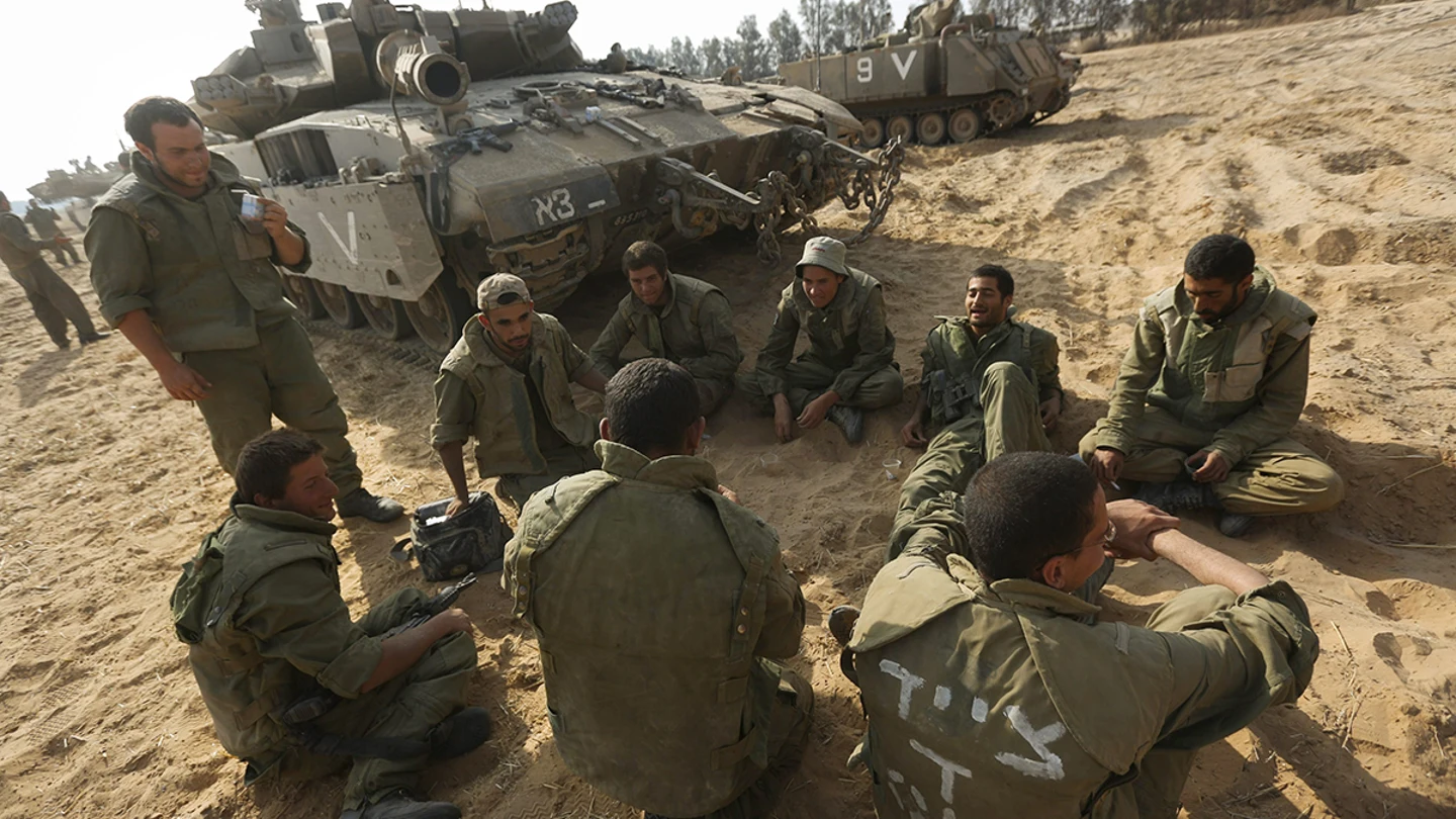 Soldados israelíes sentados al lado de sus tanques Soldados israelíes sentados al lado de sus tanques