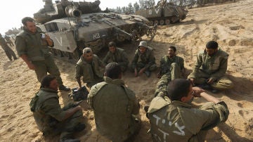 Soldados israelíes sentados al lado de sus tanques