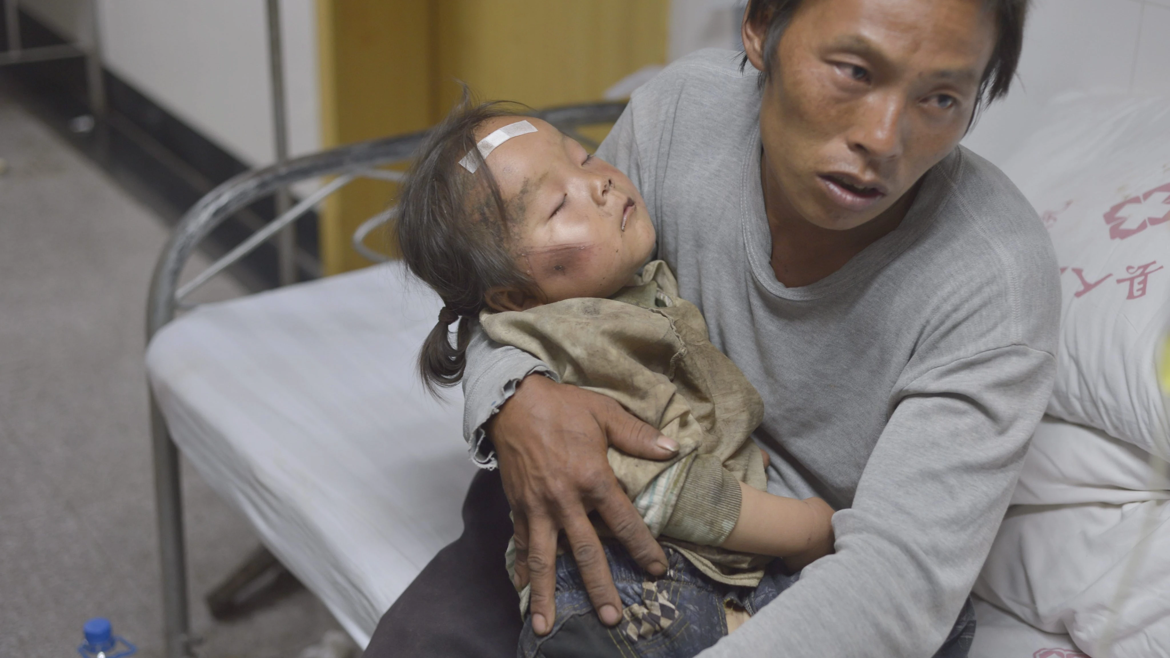 Un padre espera en el hospital ayuda para su hijo herido en el terremoto