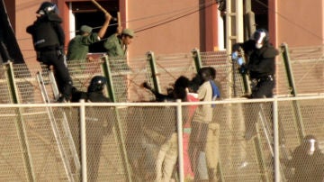 La policía marroquí hostiga a los seis inmigrantes que se encontraban encaramados a la valla de Melilla