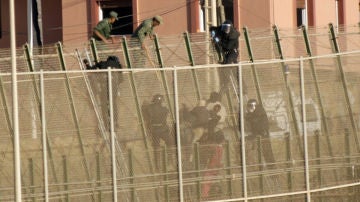 La policía marroquí hostiga a los seis inmigrantes que se encontraban encaramados a la valla de Melilla