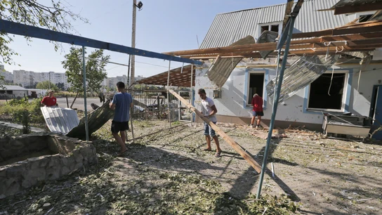 Residentes locales limpian los restos de un hotel ucraniano tras ser alcanzado por los combates Residentes locales limpian los restos de un hotel ucraniano tras ser alcanzado por los combates