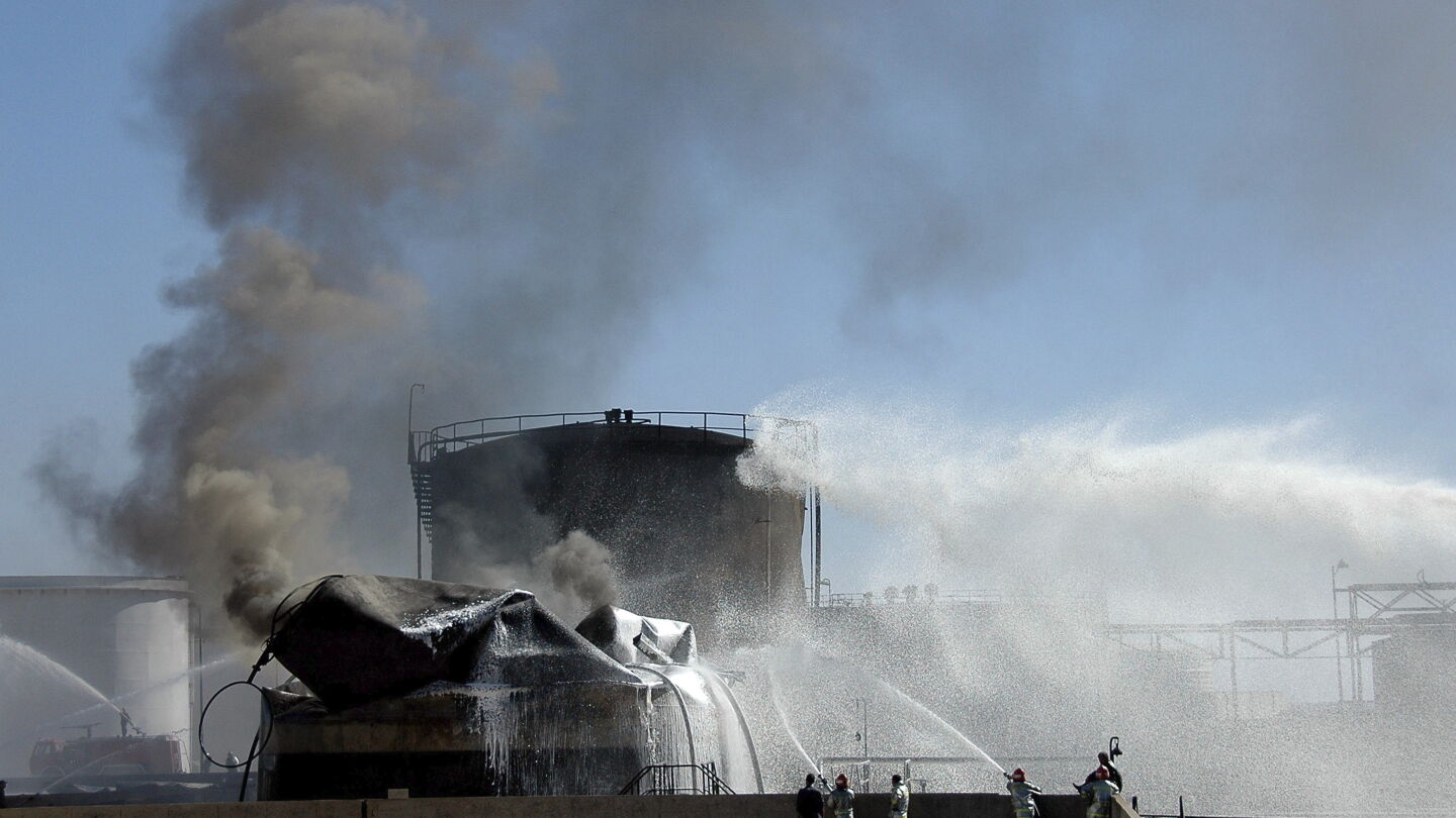 Un equipo de bomberos sirios trata de apagar un fuego en una refiner&iacute;a en Siria