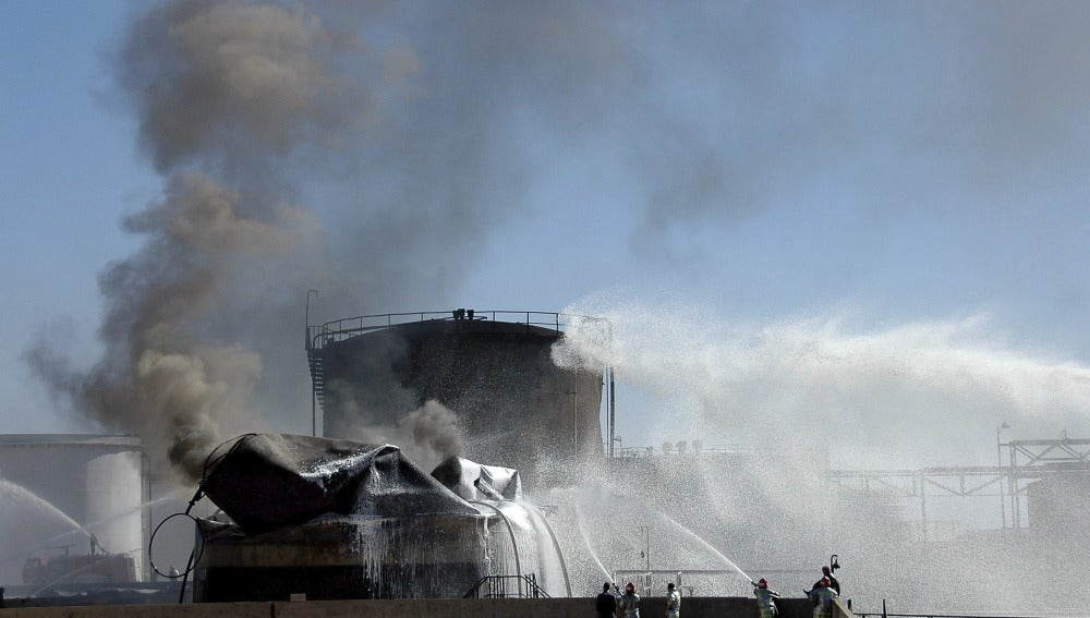 Un equipo de bomberos sirios trata de apagar un fuego en una refinería  en Siria