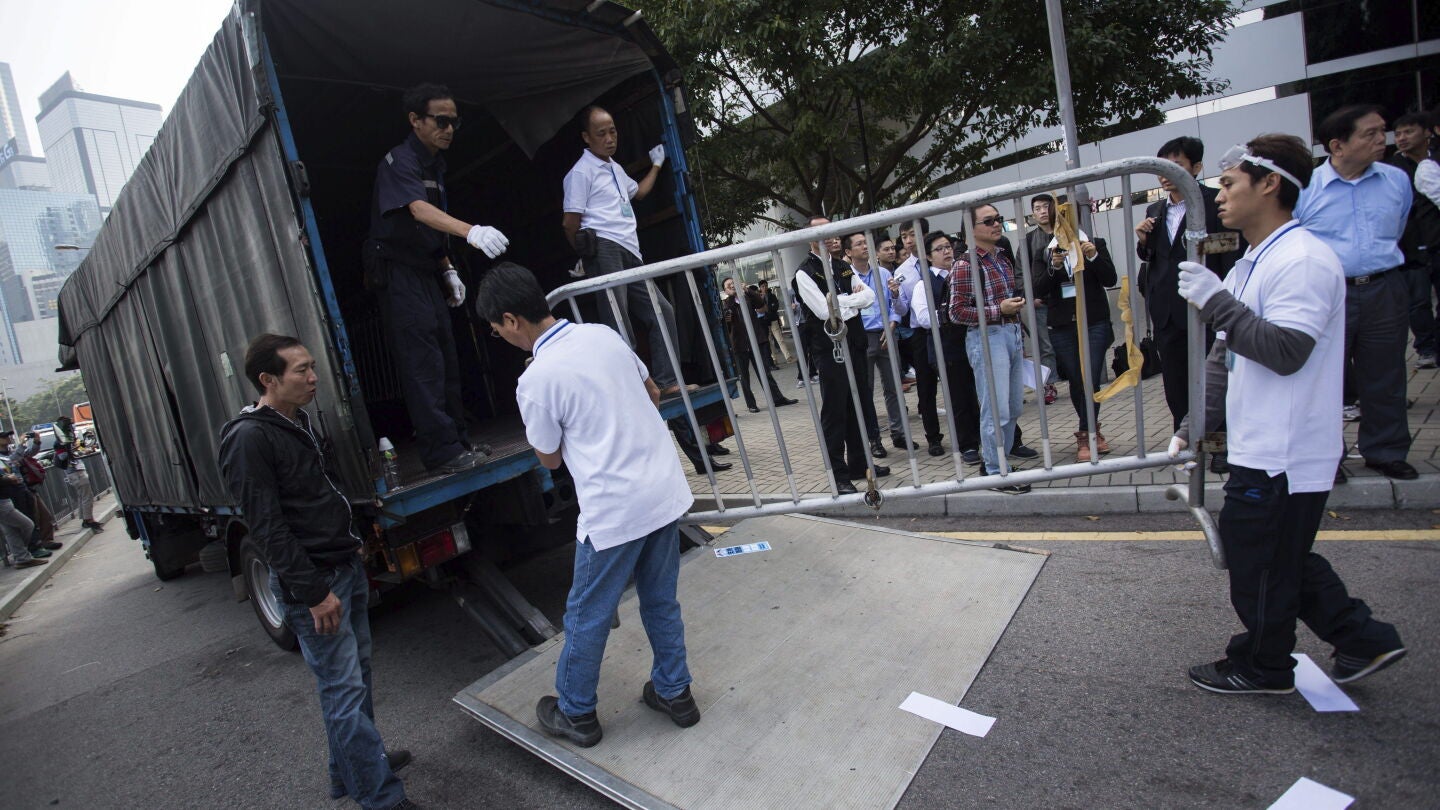 Personal del edificio de oficinas Citic Tower retira barricadas en una zona ocupada en Admiralty, en Hong Kong 