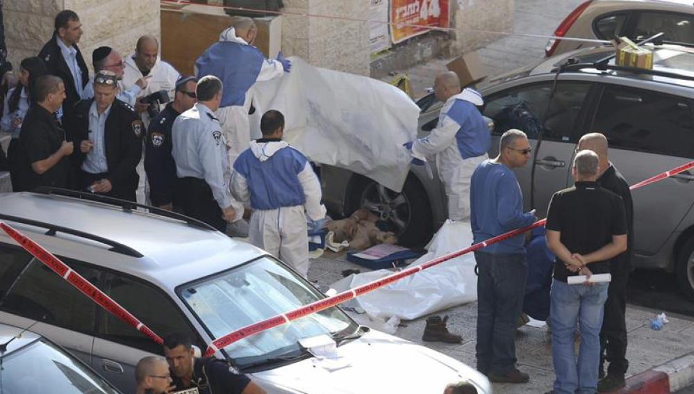 Personal sanitario cubre el cuerpo de una de las víctimas tras el ataque contra una sinagoga en Jerusalén