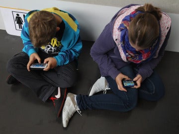 Niños consultando el móvil