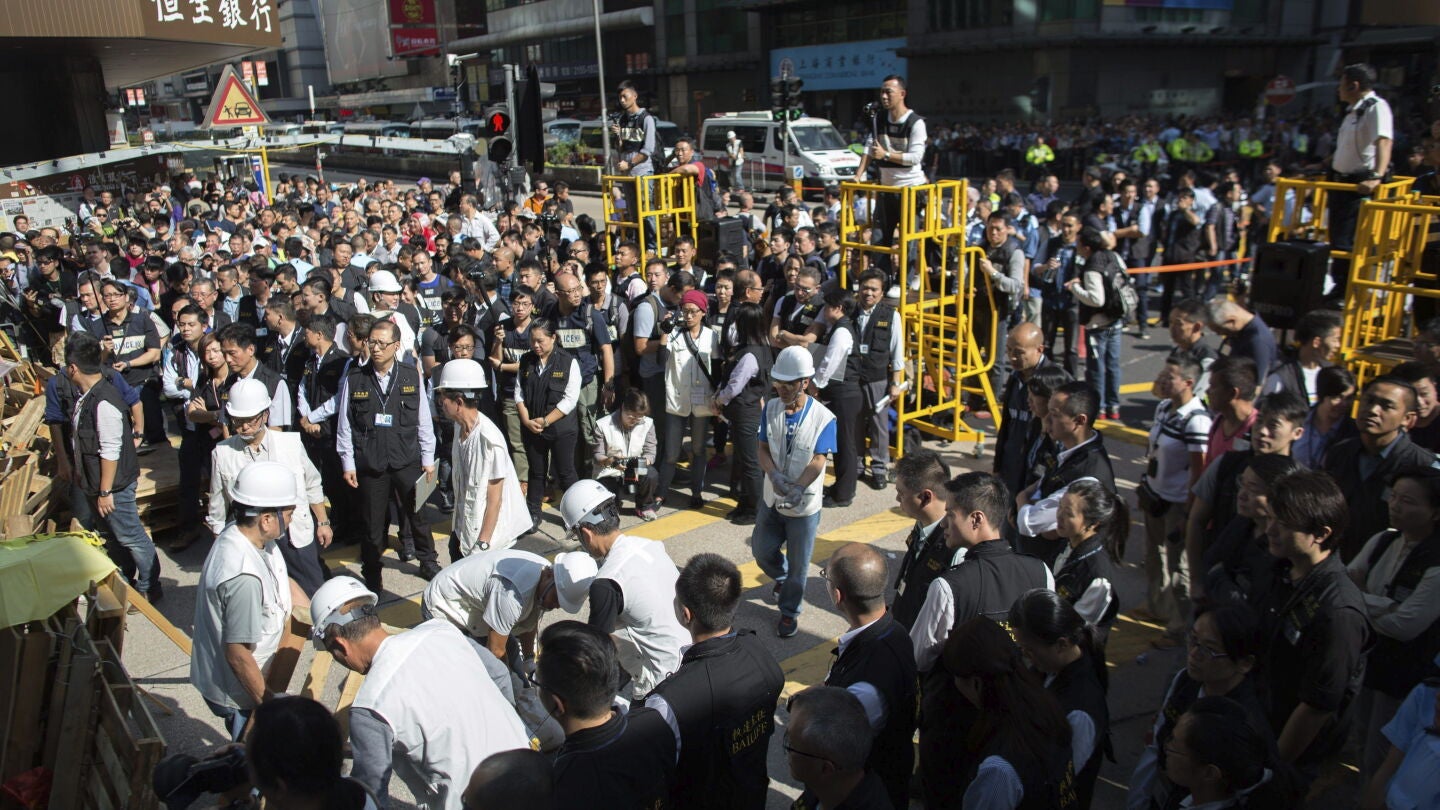 Trabajadores retiran las barricadas de una parte de la calle Argyle en el distrito de Mong Kok
