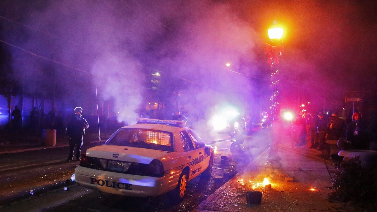 Manifestantes incendian un coche de polic&iacute;a ante el edificio del ayuntamiento en Ferguson