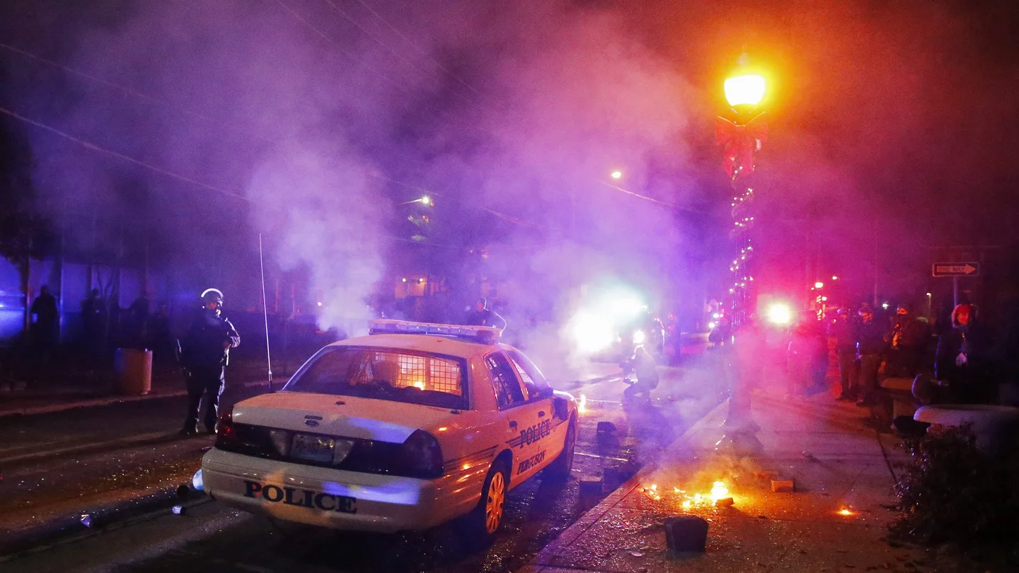 Manifestantes incendian un coche de policía ante el edificio del ayuntamiento en Ferguson Manifestantes incendian un coche de policía ante el edificio del ayuntamiento en Ferguson
