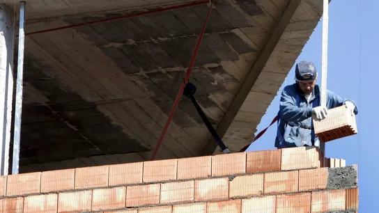Un obrero construye una vivienda Un obrero construye una vivienda